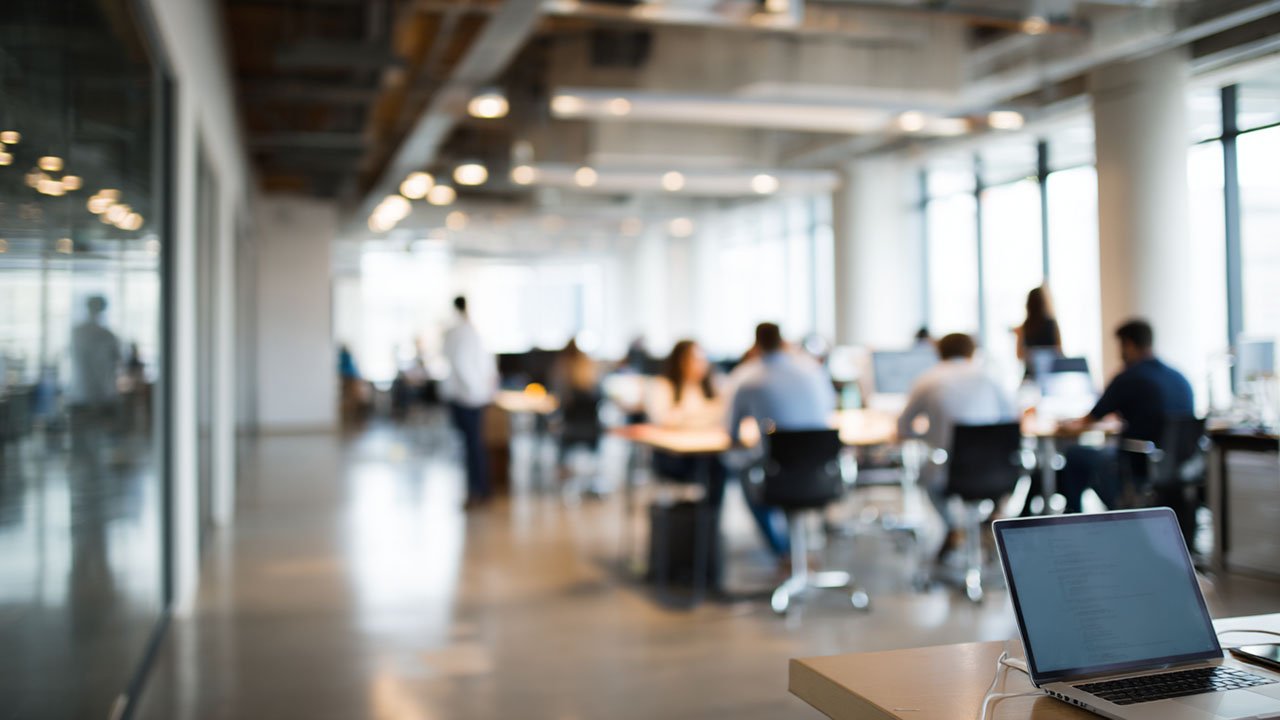 Diverse professionals in a modern workspace, engaged in learning activities linked to flexible training subscriptions.